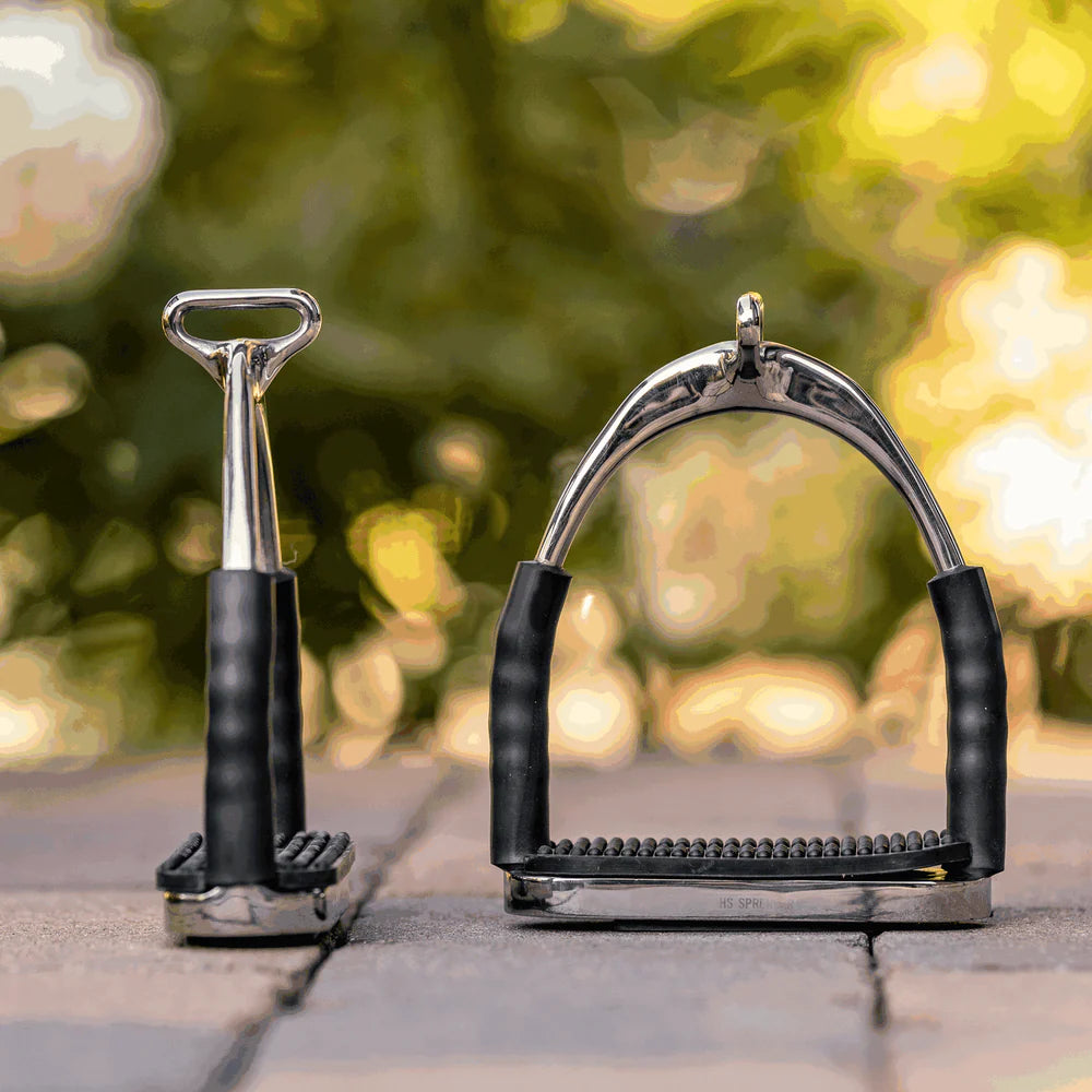 a pair of HS System-4 stirrups with black pad against blurred background