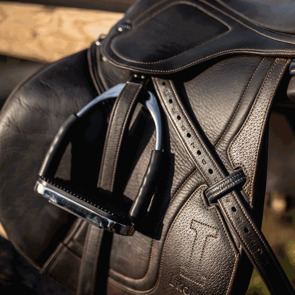 Herm Sprenger System-4 stirrups with black pads, mounted on saddle with leather stirrup straps