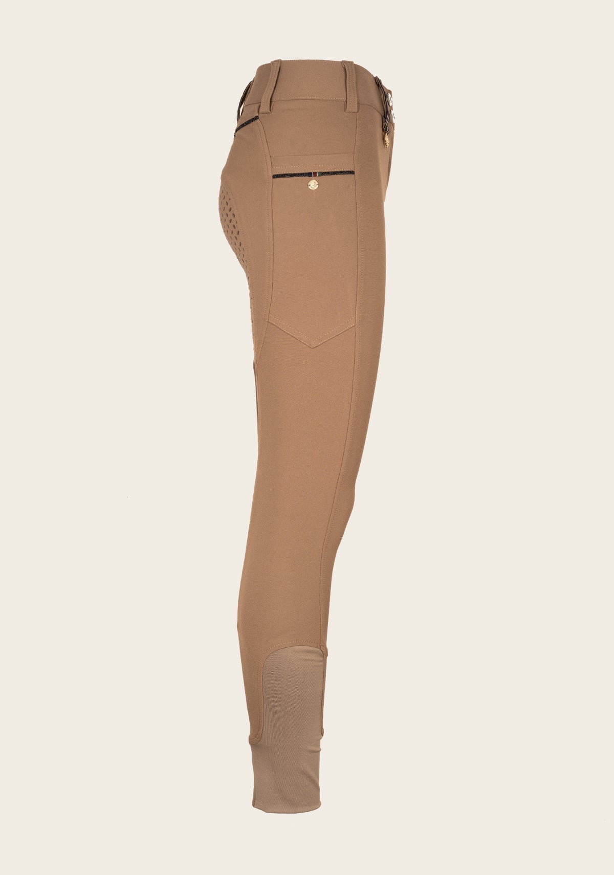 Side profile of Espoir breech highlighting phone pocket placement, golden nameplate detail, and ergonomic stretch fabric.