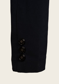 Close-up of Espoir show jacket cuff with custom gold button and fine stitching on lightweight stretch fabric.