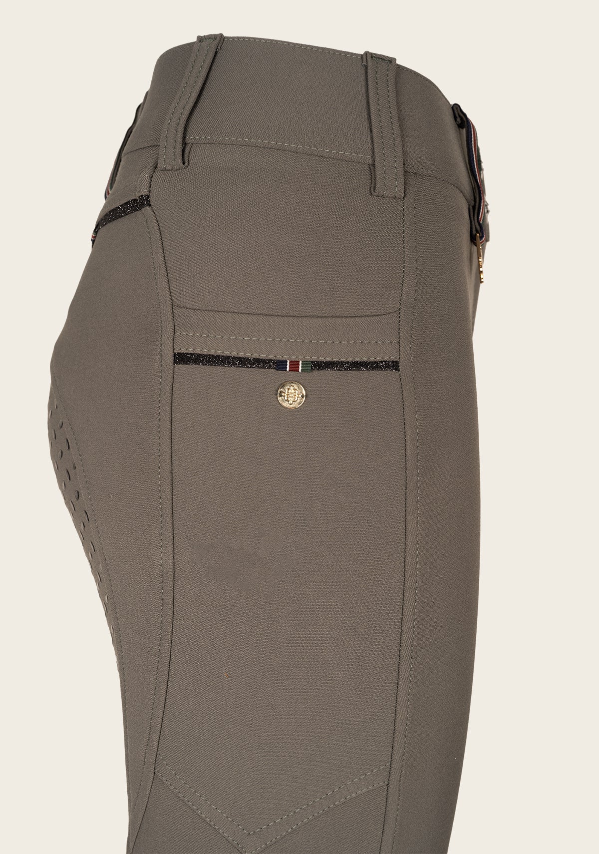 Close-up of Espoir breech phone pocket with custom golden nameplate and glitter zip detail.