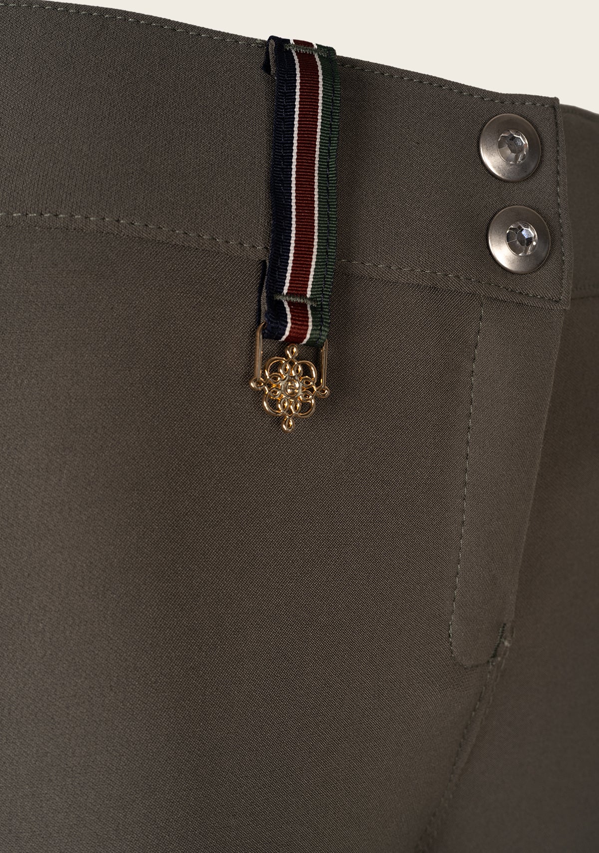 Detail view of Espoir breech crossed back belt loop in brand colors, showcasing signature design element.