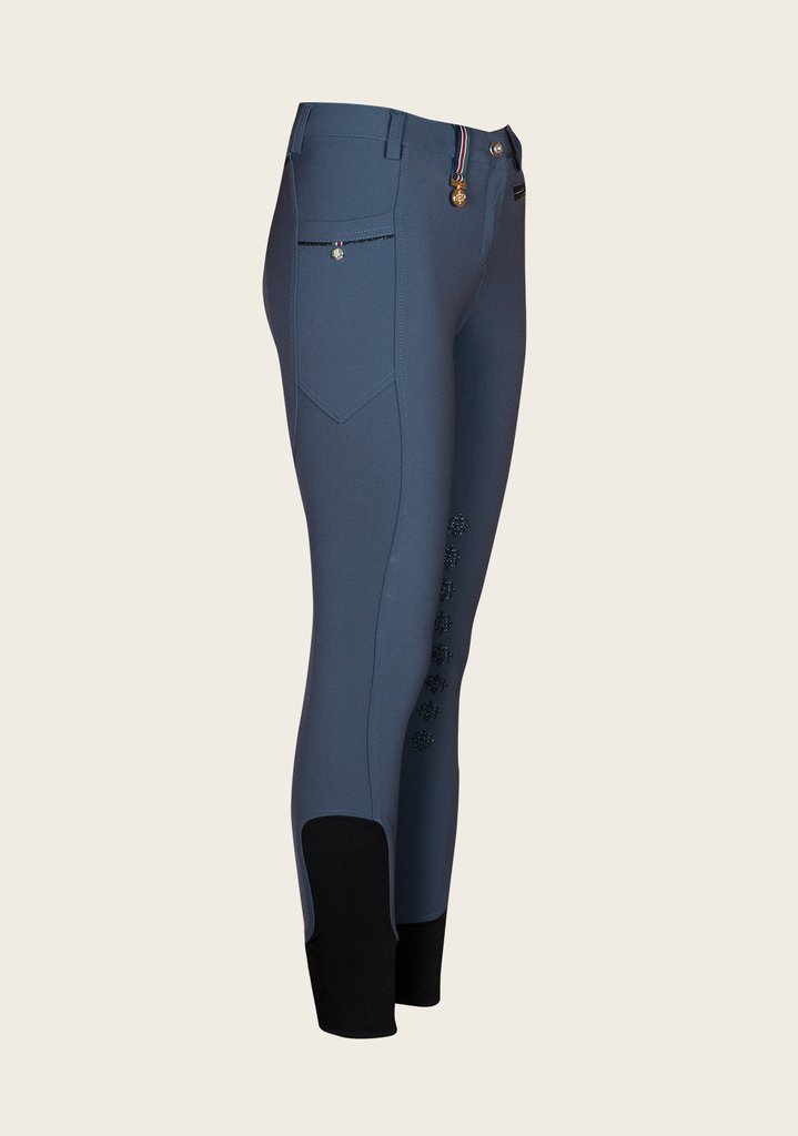 Side profile of Espoir breech highlighting phone pocket placement, golden nameplate, and contoured seam lines