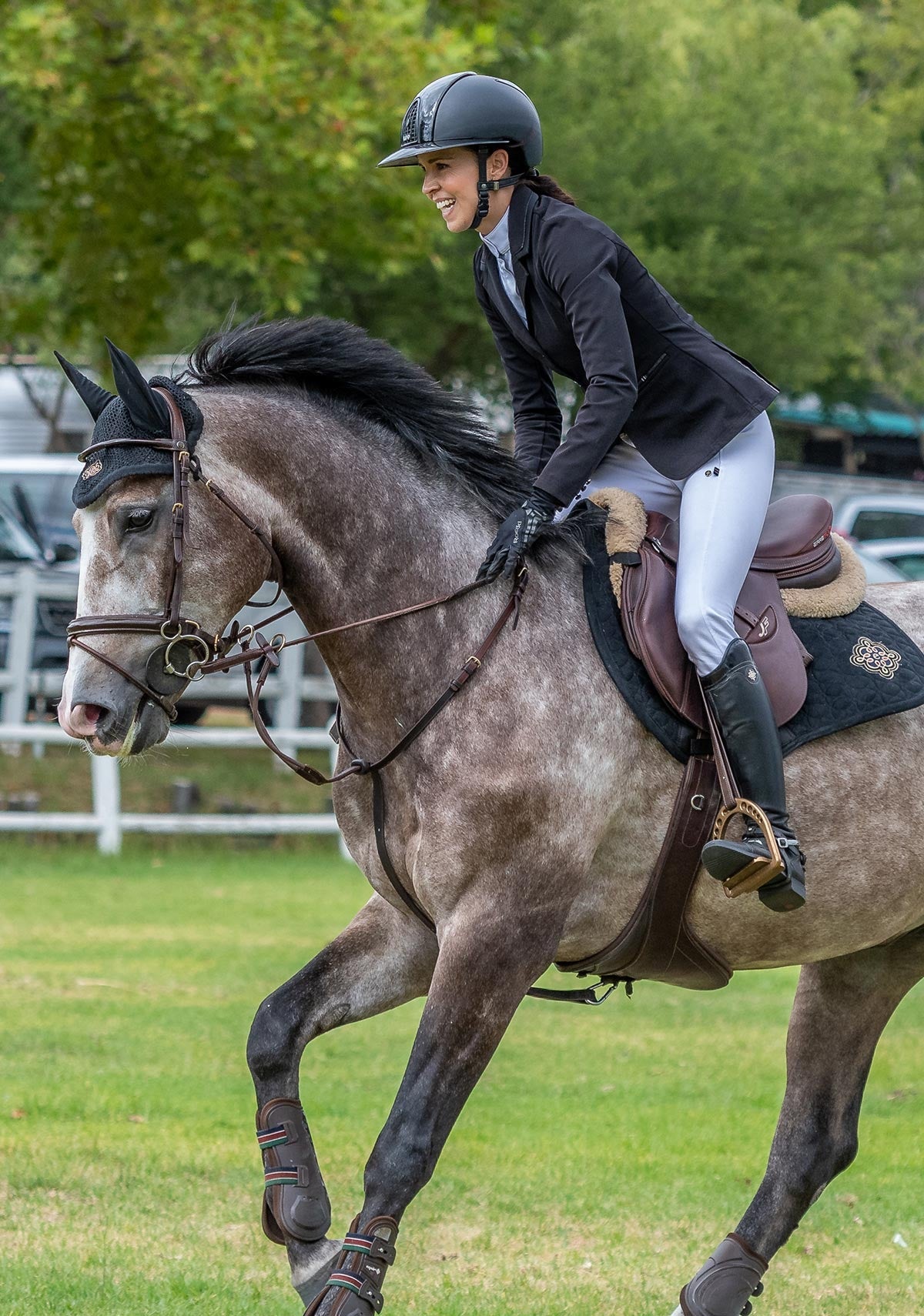 Equestrian rider jumping a horse while wearing Espoir show jacket, showcasing athletic fit, flexible fabric, and elegant competition styling